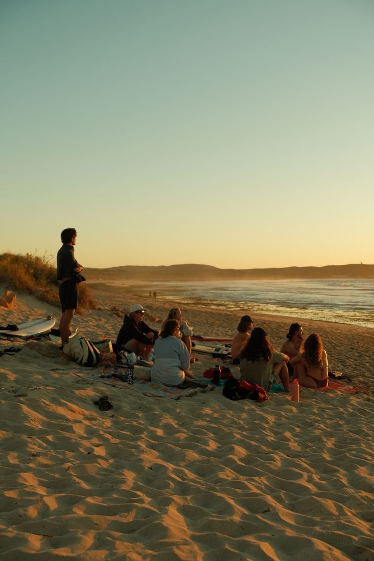 Groupe d'amis sur la plage au couché de soleil